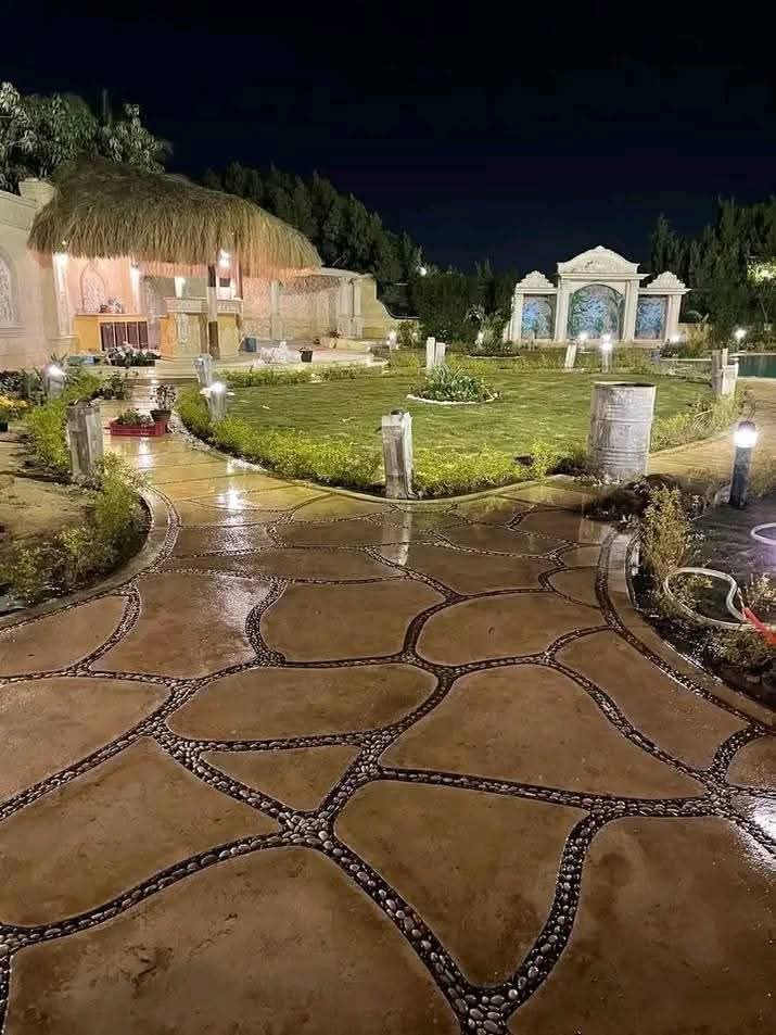حديقة استراحة نفّذها مشتل أبو جمال بممشى حجري ومظلة مضاءة ليلاً