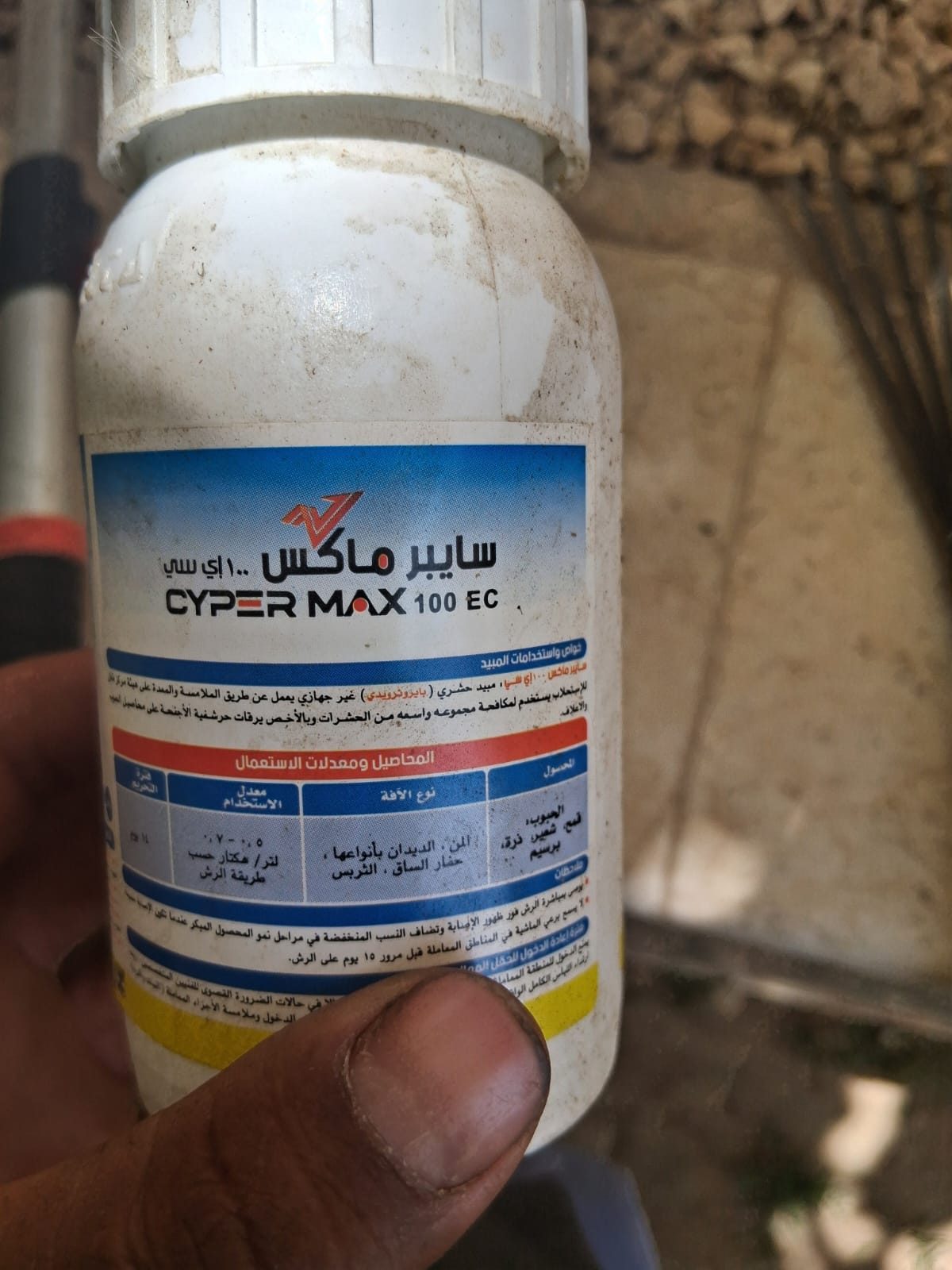 عبوة مبيد حشري في اليد أثناء أعمال مكافحة الآفات للمزروعات